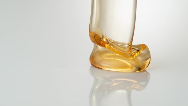 Pouring honey on reflective surface. Shot with high speed camera, phantom flex 4K. Slow Motion. 