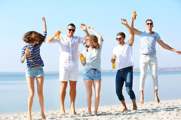 Obraz premium Young people with beer on the riverside