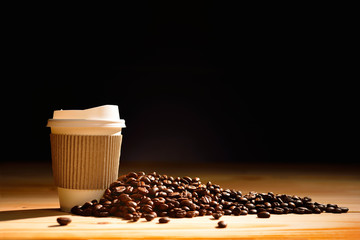 Tasse en papier de café et de grains de café sur table en bois
