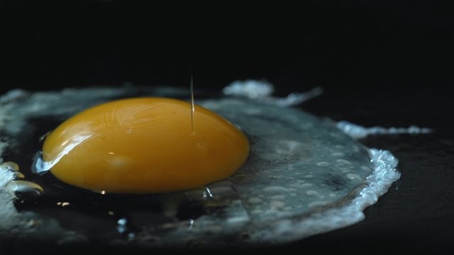 Cooking egg on fry pan. Shot with high speed camera, phantom flex 4K. Slow Motion.