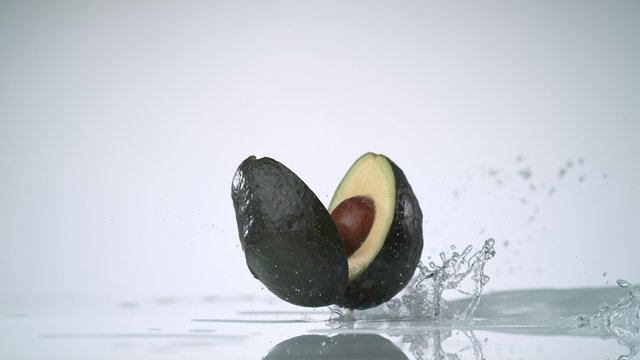 Cut avocado and water splash. Shot with high speed camera, phantom flex 4K. Slow Motion. 