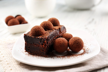 Slice of chocolate cake with a truffle on plate closeup