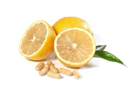 Fresh lemon and pills isolated on white, shallow focus