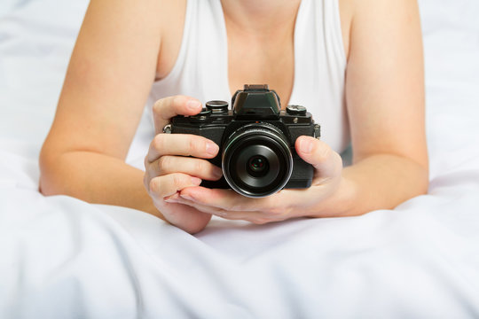 Young caucasian woman on the bed with the camera