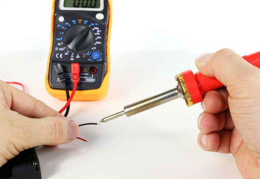 Man soldering wire with soldering iron