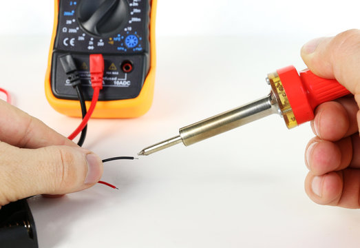 Man soldering wire with soldering iron