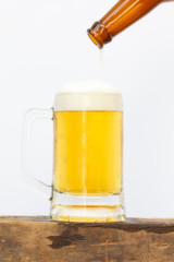 Pouring beer into glass until last with white background.