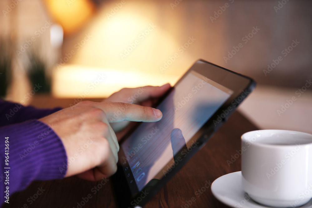 Poster Young man using his tablet-pc, close up