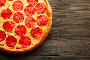 Tasty pizza with salami on wooden background, close up