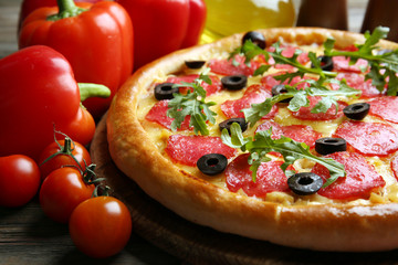 Tasty pizza with salami on decorated wooden table, close up