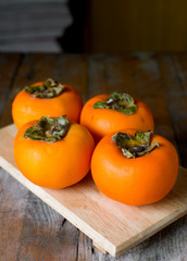 persimmon on rustic wooden background
