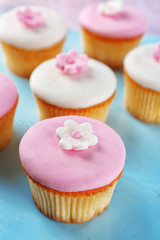 Tasty cupcakes on color wooden background