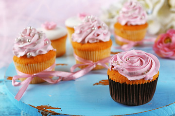 Tasty cupcakes on tray, on light background