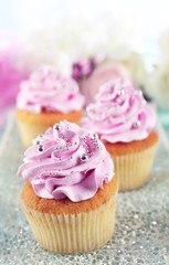 Tasty cupcakes on plate, on color wooden background
