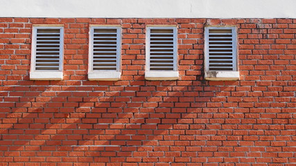 Four outlet mount on brick wall with their shadow cast on the wall