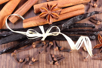 Vanilla, cinnamon sticks, star anise and cloves on wooden surface