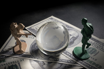 Soldier toys and glass globe on money