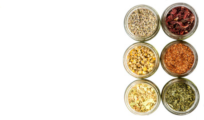 Dried herbal tea of Japanese green tea, lavender, chamomile, linden flower, hibiscus in mason jars over wooden background