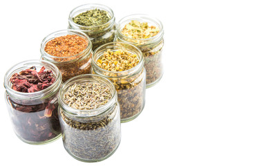 Dried herbal tea of Japanese green tea, lavender, chamomile, linden flower, hibiscus in mason jars over wooden background