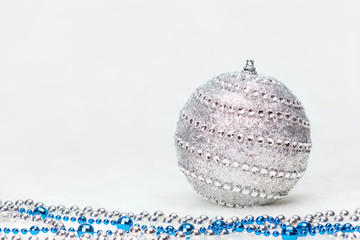 Fototapeta na wymiar Grey Christmas ball with beads on white background. Copyspace for your greeting or wishes