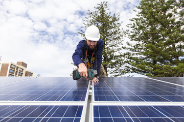 Solar panel technician with drill