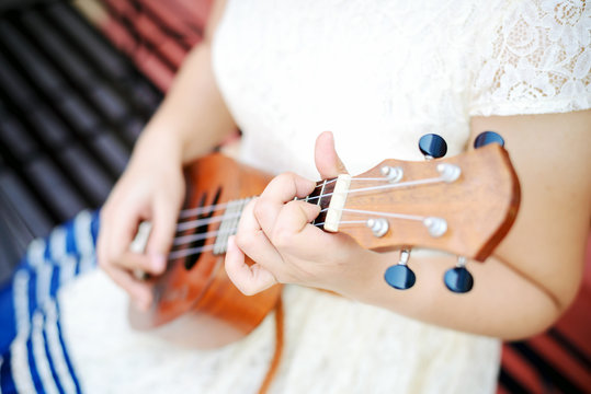 girl hand playing ukulele