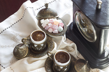 Turkish coffee with delight and traditional copper serving set, vintage clock