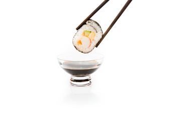 Dipping roll in sauce isolated on white