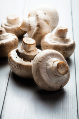 White button mushrooms on a wooden blue table