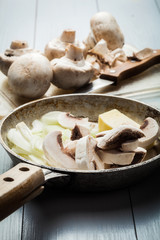 Sliced mushrooms with onion on a pan