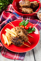 Barbecued kofta with fries on a plate