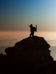 Silhouette of a photographer on the top of the mountain