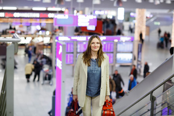 woman at international airport waiting for flight at terminal