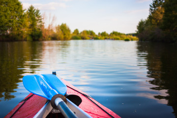 Blue paddle lying on kayak. Kayaking in a river