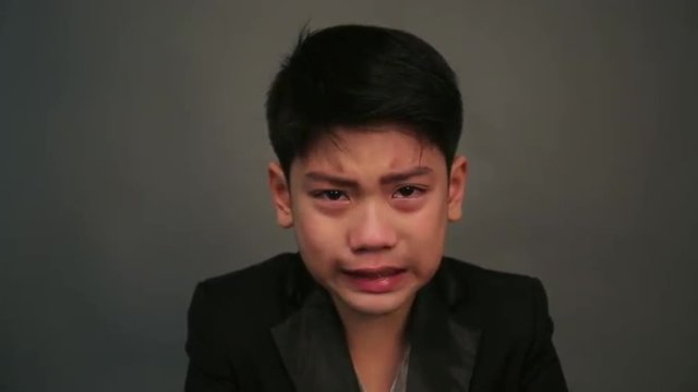 Portrait of asian child crying and angry on gray background