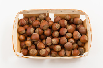 Obraz premium wooden container is filled with hazelnut on a white background