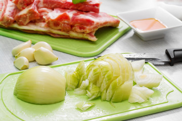 Cutting onions to prepare the marinade for pork ribs.  Step on s