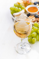 glasses of white wine and snacks , vertical