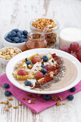 oatmeal with assorted fresh fruits, nuts and chia in plate