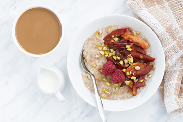 oatmeal with baked fruit and fresh coffee with milk, top view