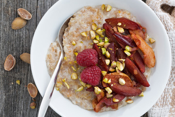 oatmeal with baked fruit and pistachios for breakfast, top view