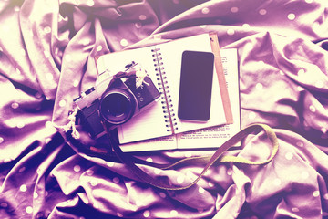 Blank black smartphone with diary, vintage camera and book