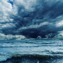 stormy sky over dark sea with waves