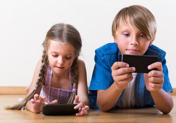 children looking at screen of smartphones