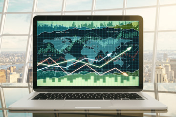 Business chart on laptop screen on glassy table with city view