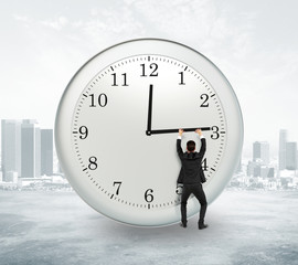 Stop timing concept with businessman trying to stop the time at