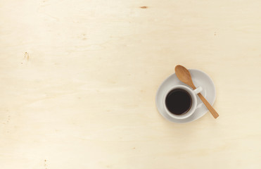 Black coffee with wooden spoon on wood background