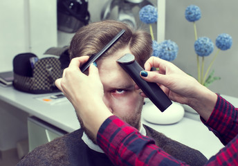 Naklejka premium The young man at the hairdresser salon hairstyle make model