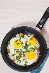 fried eggs with bacon in a frying pan