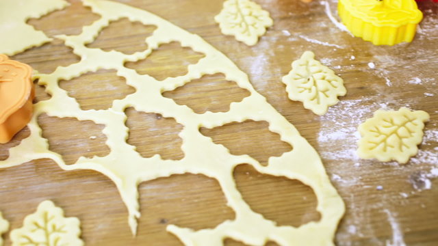 Cutting out Autumn leafs with cookie stamper to decorate pumpkin pie